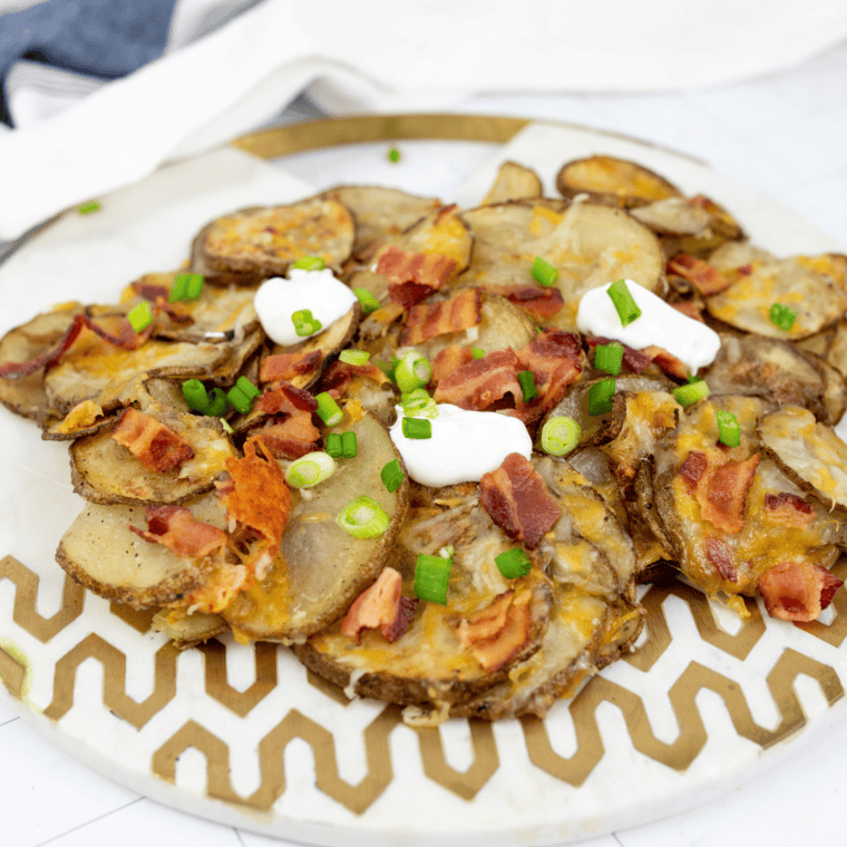 Loaded Blackstone potato chips topped with melted cheddar, crumbled bacon, sour cream, and chives