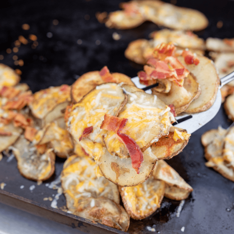 Close-up of loaded Blackstone potato chips with melted cheddar and crispy bacon