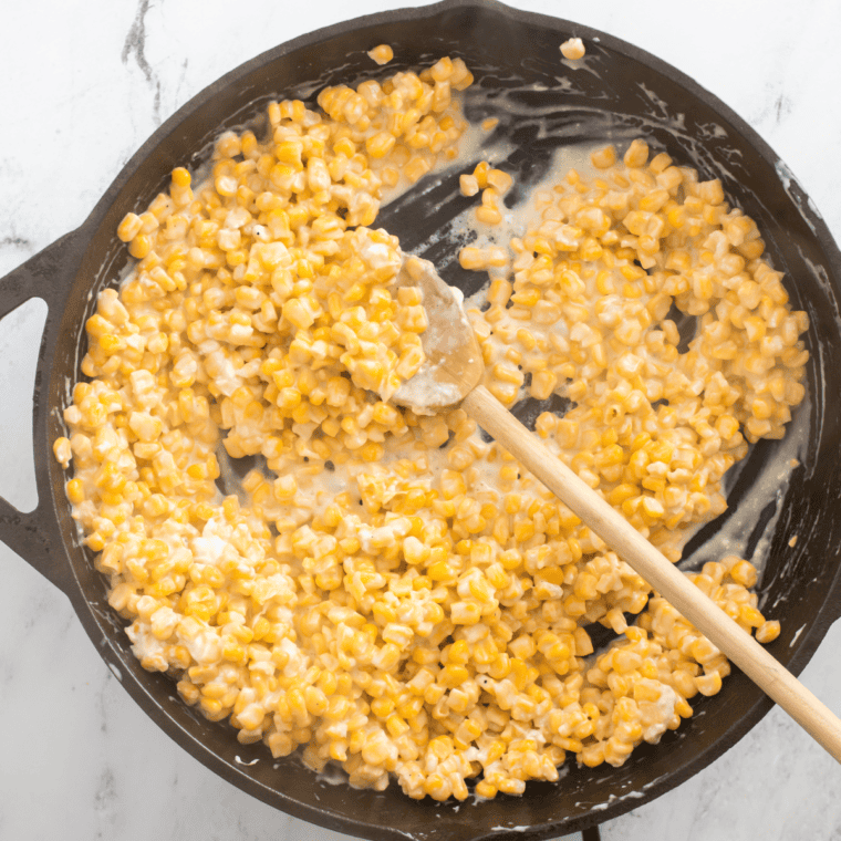Stirring cream cheese in a pan until fully melted and seasoned with salt and pepper.