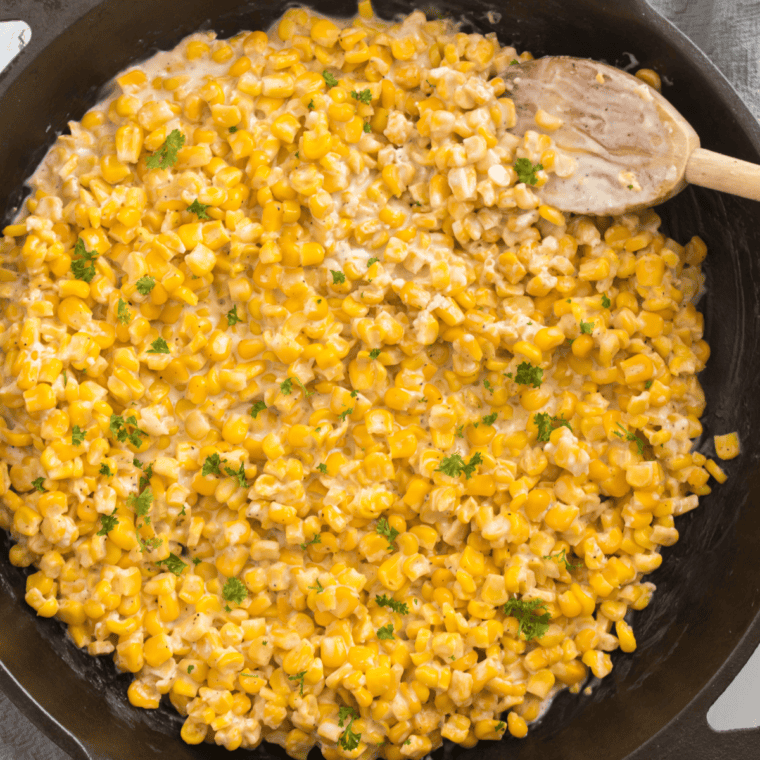 Cast iron skillet with creamy corn, butter, honey, and cream cheese, cooked to perfection.