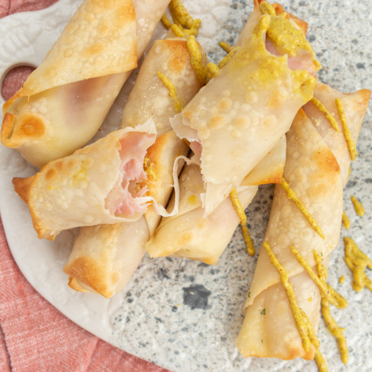 Golden brown Air Fryer Ham and Mozzarella Cheese Sticks with a crispy exterior and melted cheese, served with dipping sauce.
