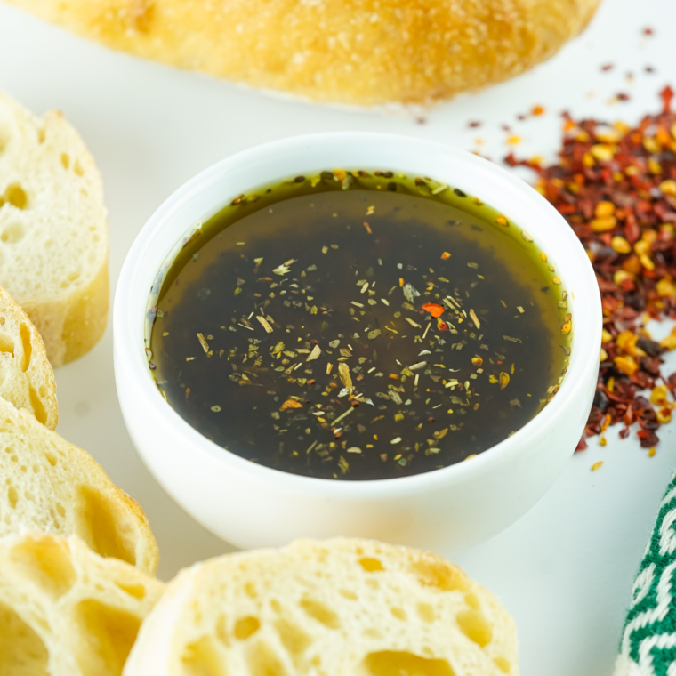 Bowl of Copycat Bonefish Grill Bread Dipping Oil with bread on the side.