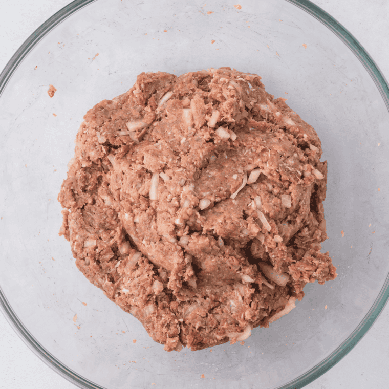Mixing ground beef, Ritz crackers, eggs, cheese, milk, and seasonings for Cracker Barrel meatloaf.