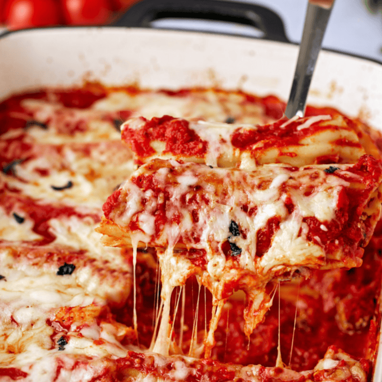 Stuffing manicotti shells with ricotta, mozzarella, and Parmesan cheese.