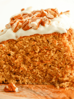 Slice of Copycat Cracker Barrel Carrot Cake topped with cream cheese frosting and chopped nuts.