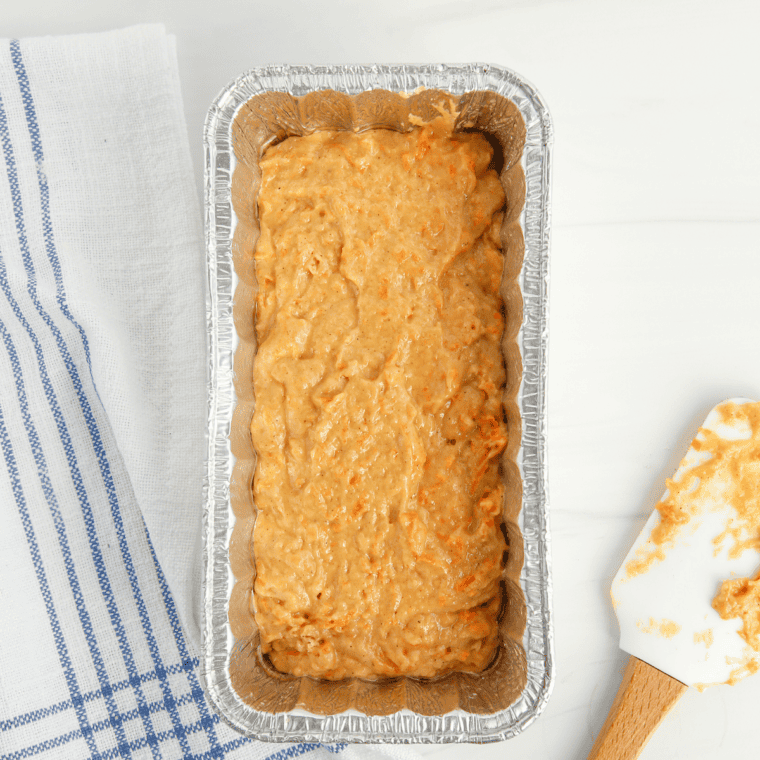 Pouring the batter into a prepared cake pan, filling about 3/4 full, and tapping the pan gently on the counter to release air bubbles.
