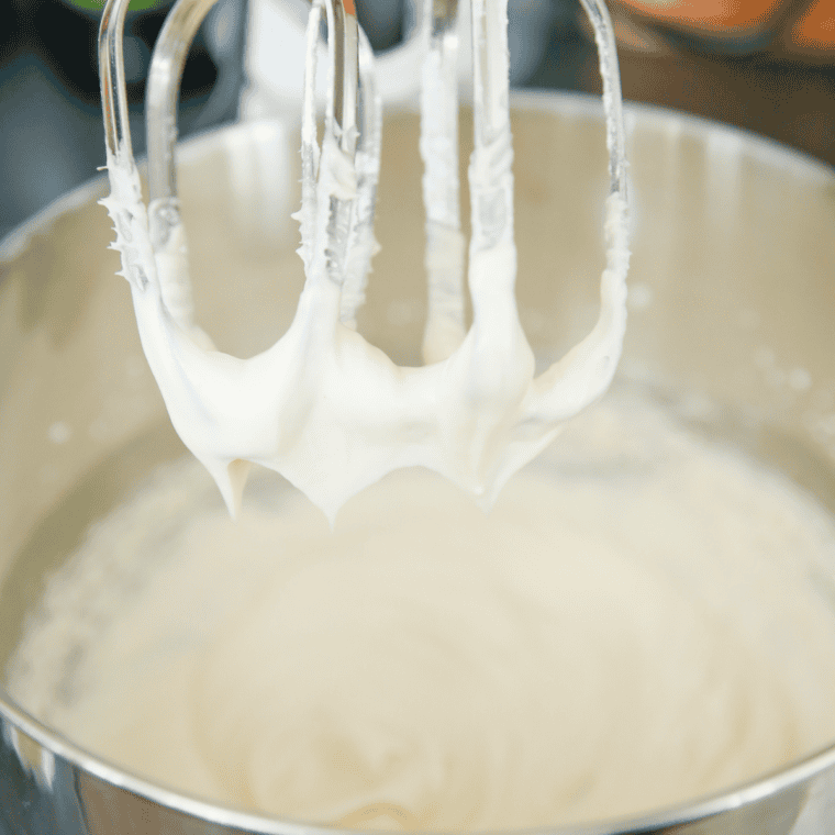 Making cream cheese frosting in a large mixer.
