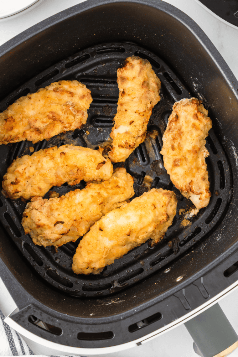 Golden crispy Cracker Barrel Fried Chicken Tenders with dipping sauces and sides.