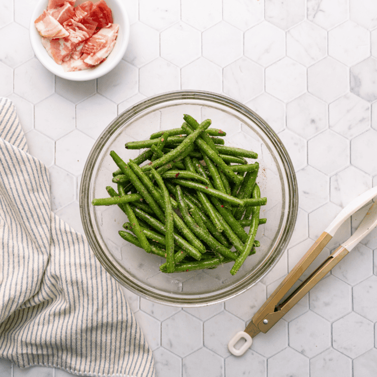 Cut green beans in a large clear bowl.