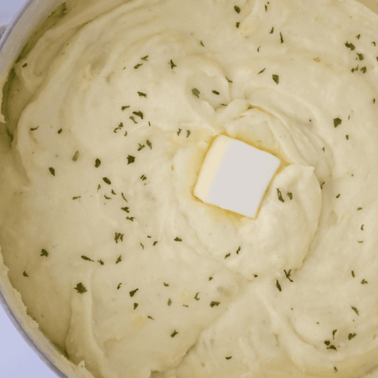 Plate of Cracker Barrel Mashed Potatoes topped with melted butter and parsley