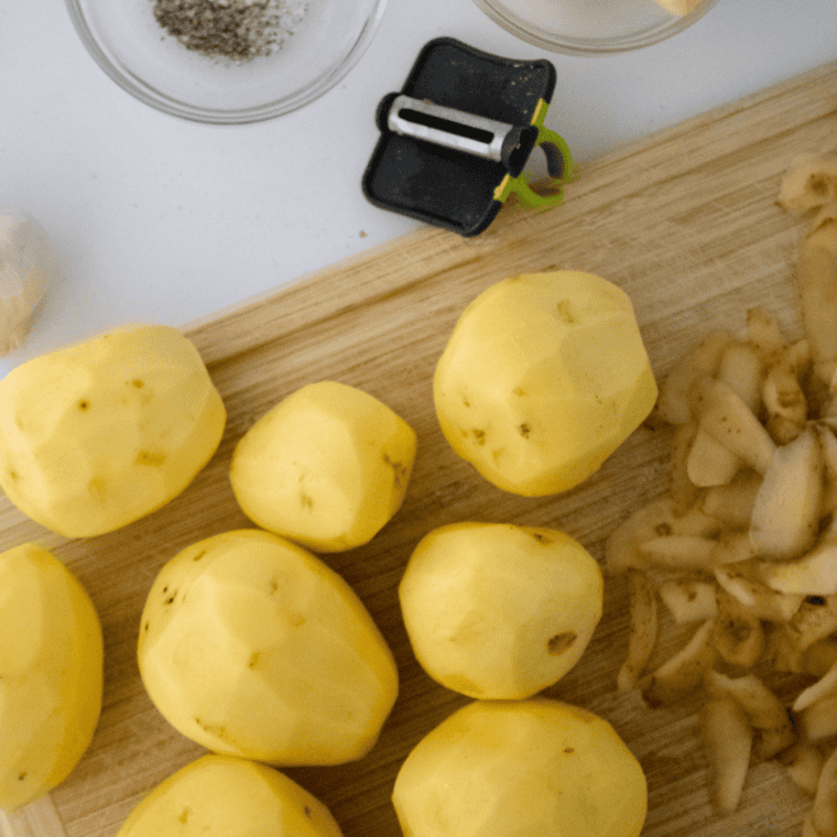 Peeled potatoes on cutting board, ready for dicing.