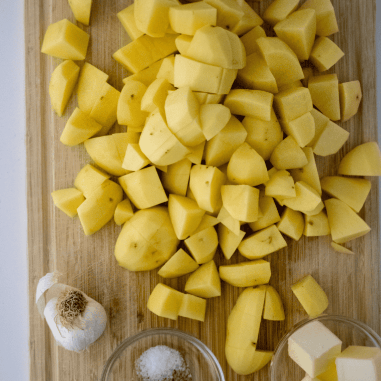 Chopped Russet potatoes on a cutting board, ready for boiling