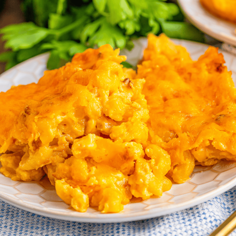 Bowl of creamy 3 cheese mac and cheese with melted cheese and herbs on top.