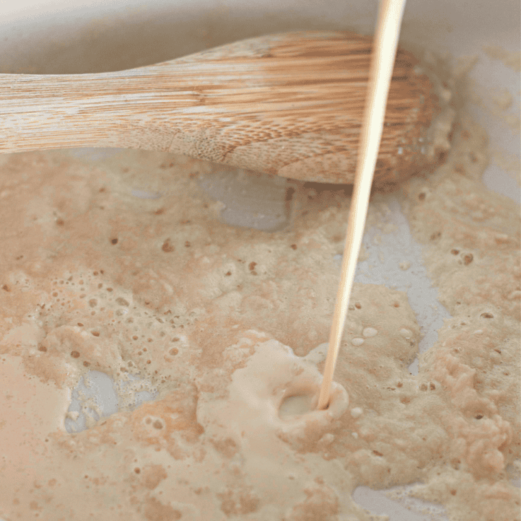 Butter and flour mixture being whisked in a large pot over medium heat until golden and bubbly.