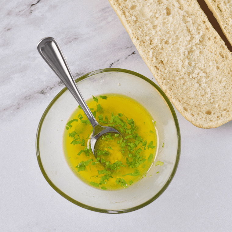 In a medium bowl, melted butter, grated Parmesan cheese, minced garlic, dried marjoram, basil, oregano, parsley, and salt mixed together for garlic bread spread.
