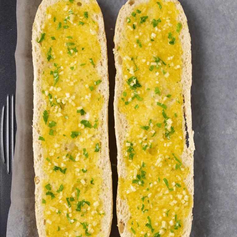 Slice of French or Italian bread spread generously with garlic butter mixture on the cut sides.