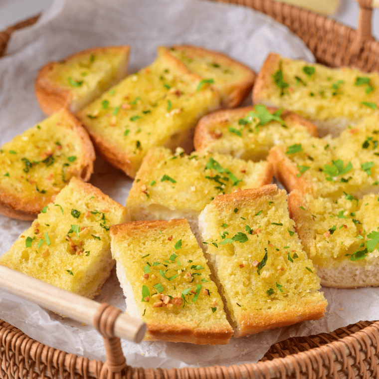 Easy Garlic Bread Spread made with butter, garlic, and herbs spread on a loaf of bread, ready to bake.