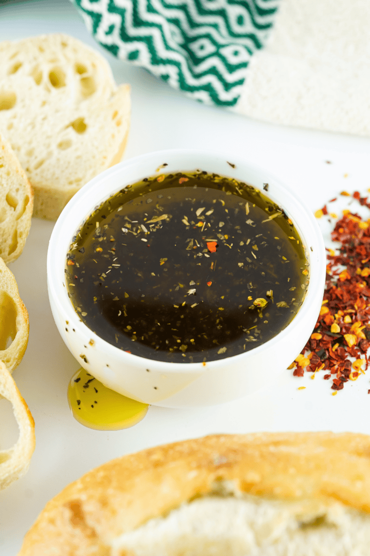 Mediterranean Greek bread dipping oil served with fresh bread slices on a rustic table.
