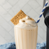 Thick and creamy Ninja Creami copycat Sonic Cheesecake Milkshake topped with whipped cream and a cherry.