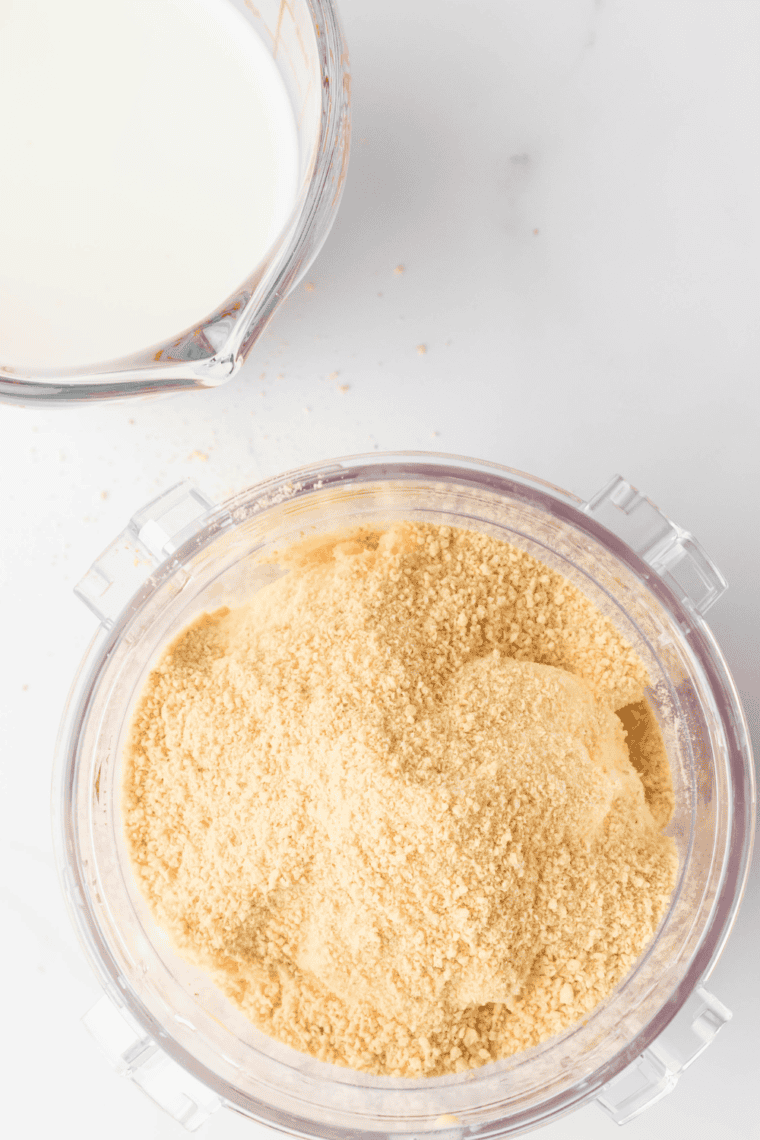 Folding crushed graham crackers into a creamy milkshake mixture using the Ninja Creami Mix-In function.