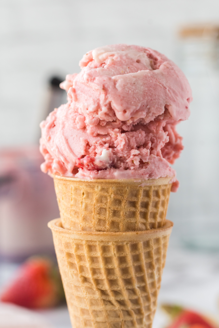Bowl of Ninja Creami dairy-free strawberry ice cream topped with fresh strawberry slices.