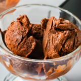 Scoop of Ninja Creami frozen hot chocolate in a bowl, topped with whipped cream and chocolate shavings.