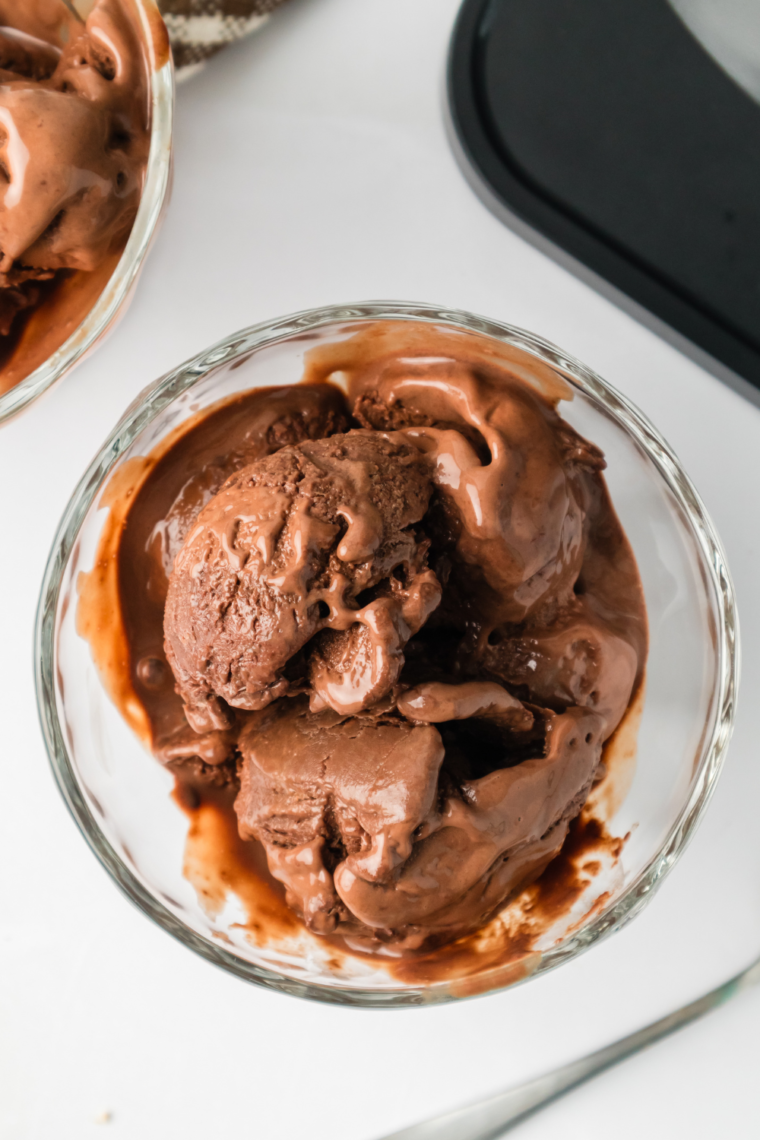 Scoop of Ninja Creami frozen hot chocolate topped with whipped cream and a sprinkle of chocolate shavings.