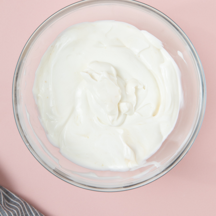 Mixing Greek yogurt, honey, and vanilla in a bowl until smooth.