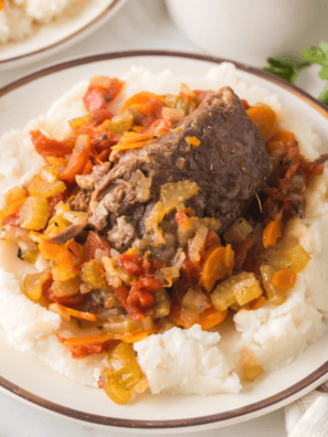 Ninja Foodi Beef Osso Buco served with vegetables and rich sauce on a white plate.