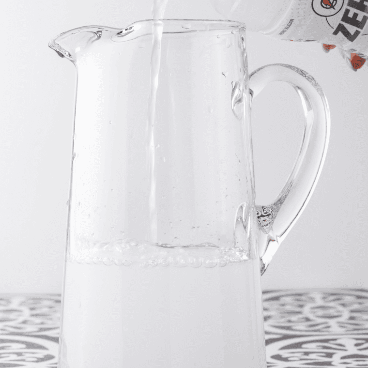 Mixing ingredients in a large glass pitcher.