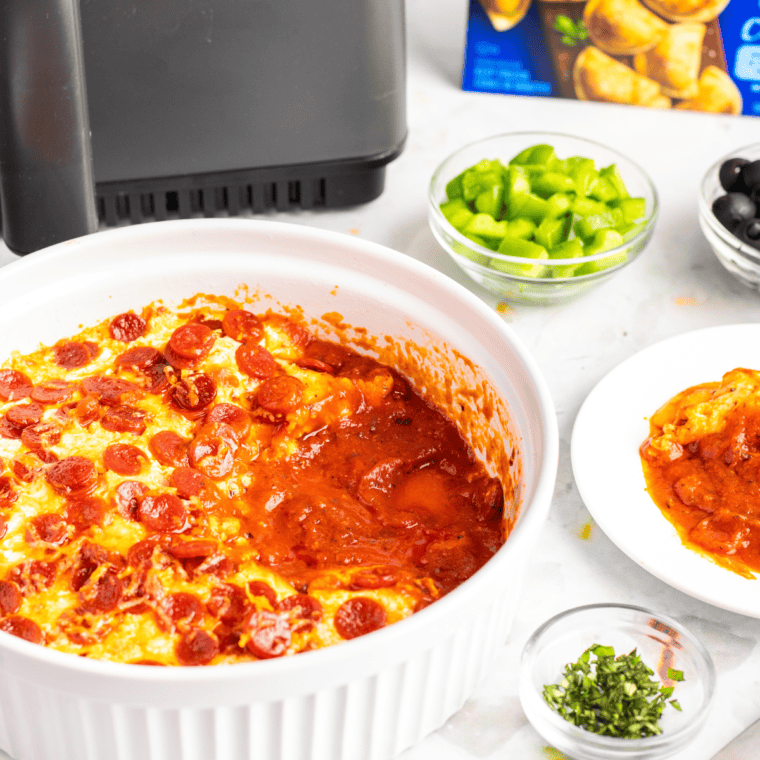 Baked Pepperoni Pierogy Pizza Casserole in a dish topped with melted cheese and crispy pepperoni.