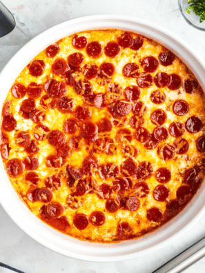 Cheesy air fryer pepperoni pierogy pizza casserole served in a dish with golden edges and melted cheese.