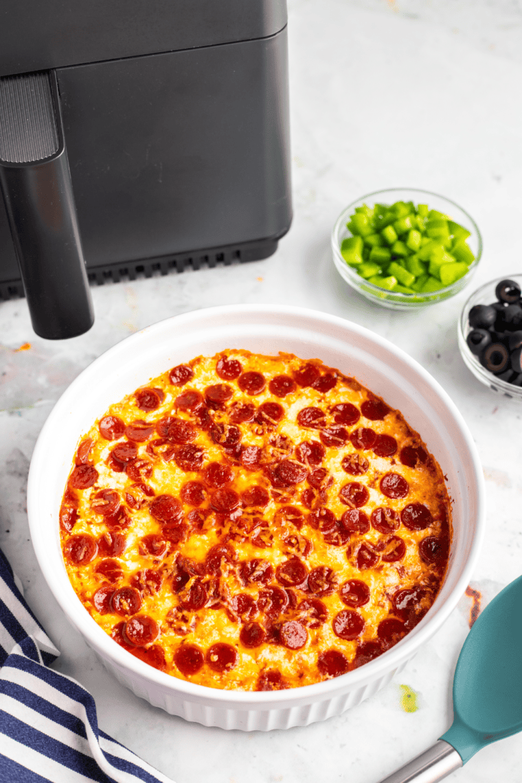 Cheesy Pepperoni Pierogy Pizza Casserole cooked in the air fryer, topped with mini pepperoni, melted mozzarella, and fresh basil.
