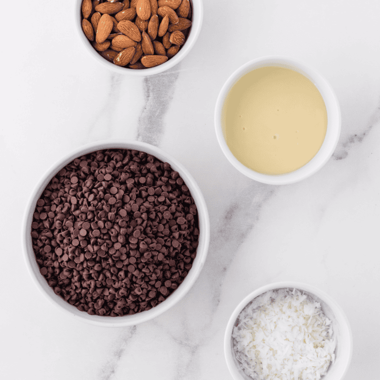 Ingredients needed for Slow Cooker Almond Joy Chocolate Clusters on kitchen table.