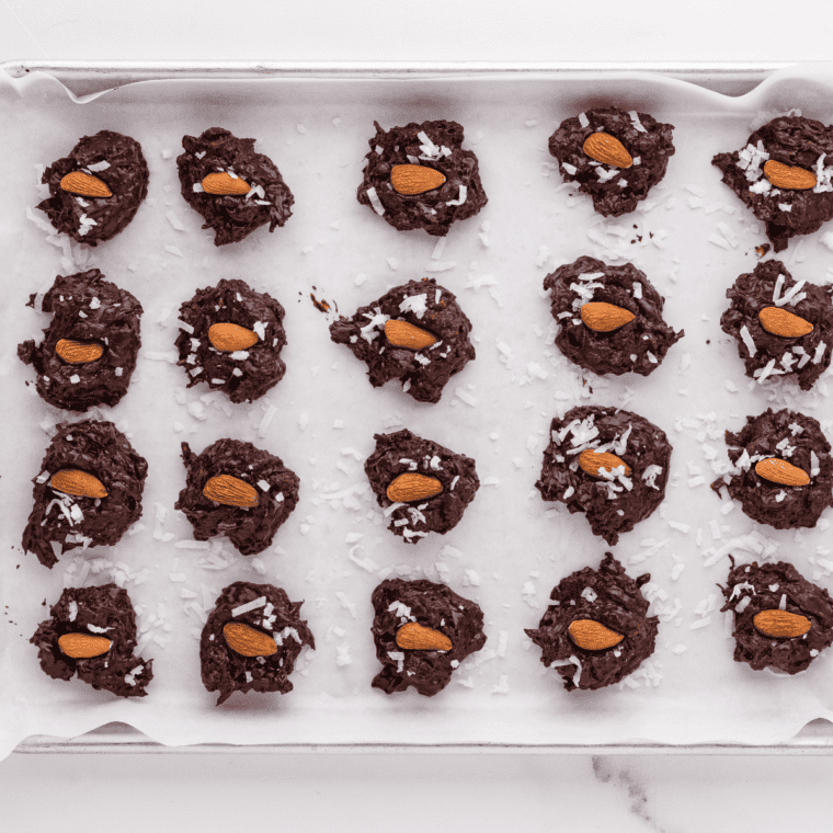 Rolling melted chocolate mixture into balls and placing them on a parchment-lined baking sheet.