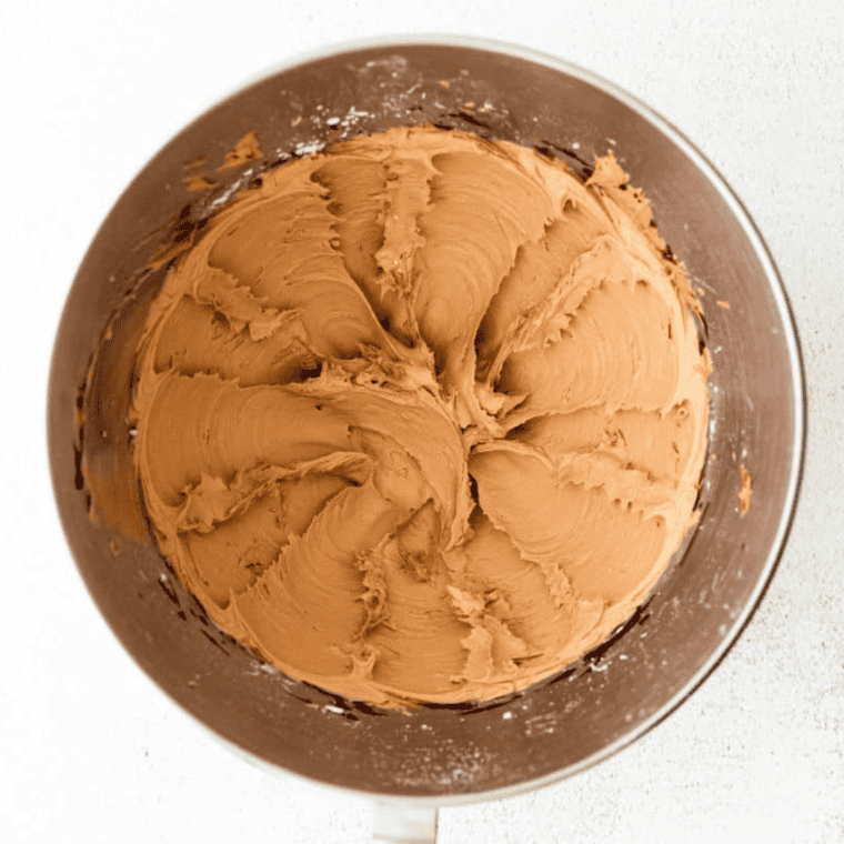 Beating softened butter and vanilla extract in a mixing bowl with an electric mixer until light and fluffy.