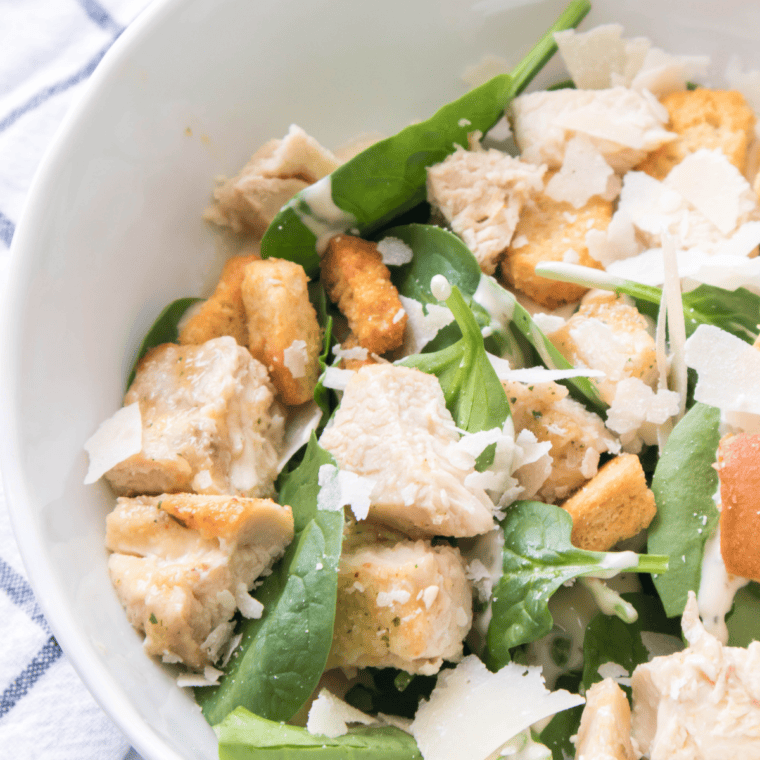 Bowl of Spicy Caesar Salad with crisp romaine, zesty dressing, grated Parmesan, and crunchy croutons.
