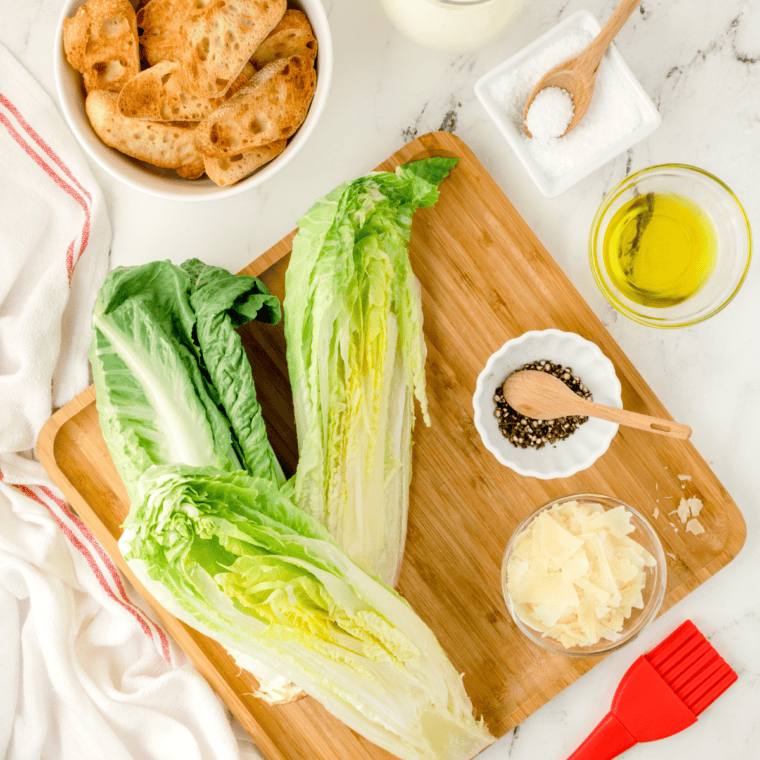 Ingredients needed for Spicy Caesar Salad on kitchen table.