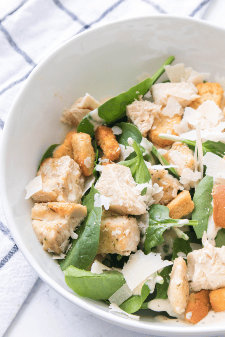 Spicy Caesar Salad with crisp romaine, spicy dressing, Parmesan cheese, and crunchy croutons in a bowl.