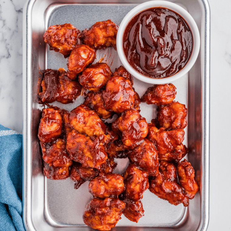 Thick Sweet Honey Bourbon BBQ Sauce in a glass jar with a brush and sauce drizzled nearby.