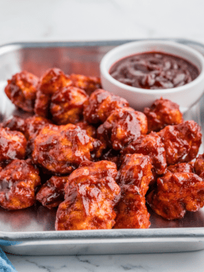 Jar of Sweet Honey Bourbon BBQ Sauce with a basting brush and fresh ingredients nearby.