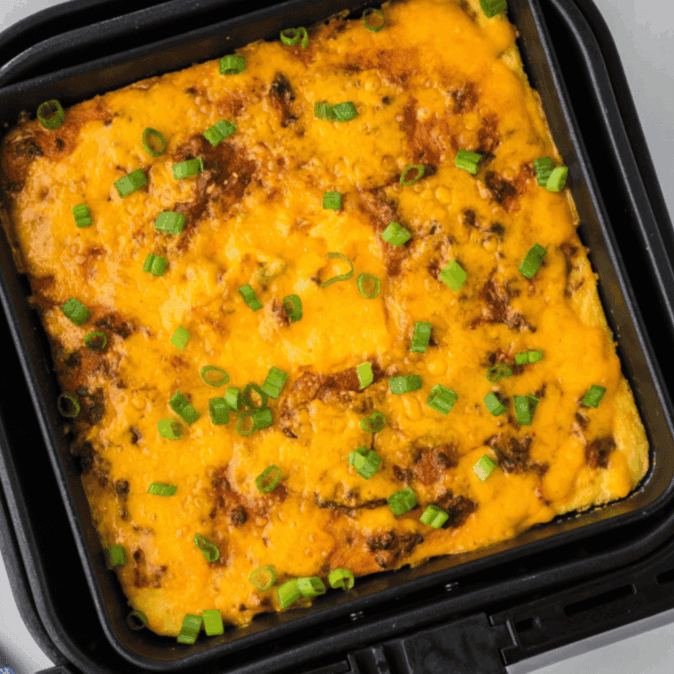 Air fryer ground beef casserole topped with melted cheddar in a white baking dish
