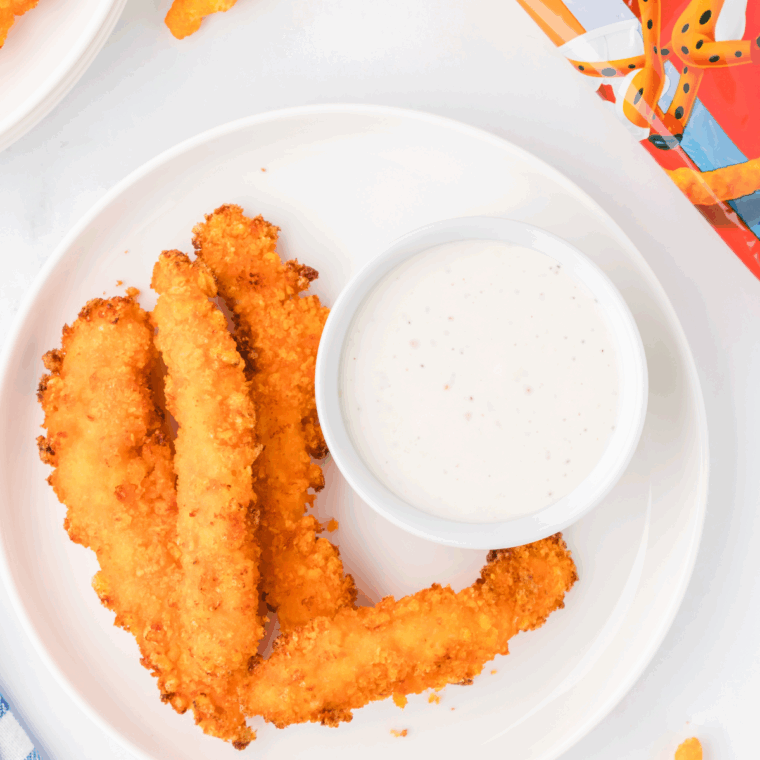 Air fryer Cheetos chicken fries piled on a plate with crispy orange crust