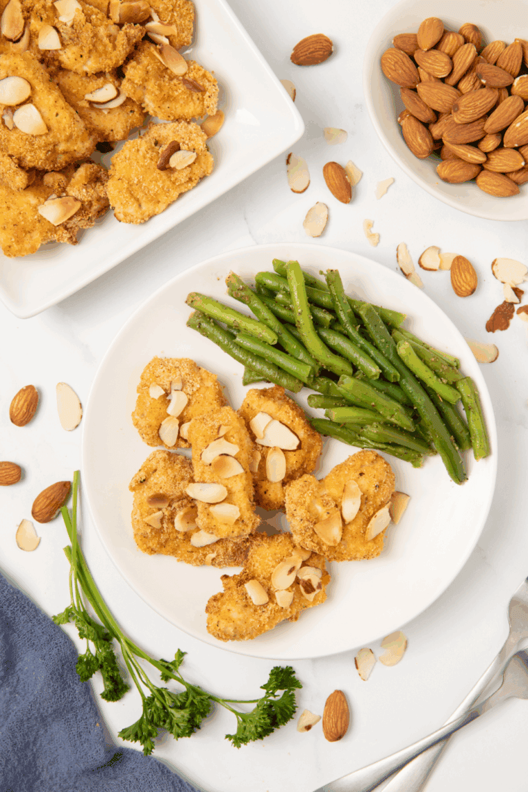 Plate of Air Fryer Panda Express Almond Chicken Recipe with green beans on a white plate.