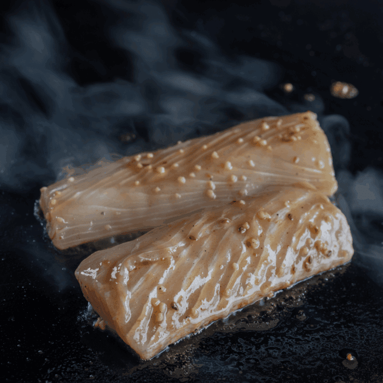 Mahi mahi fillets searing on an oiled Blackstone griddle over medium heat