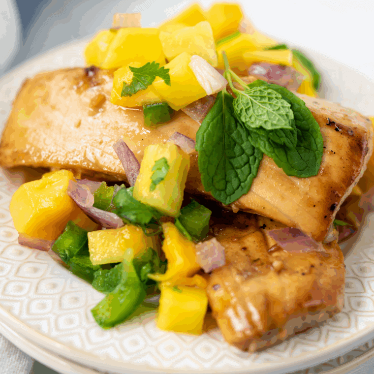 Tender Blackstone mahi mahi plated and topped with fresh tropical fruit salsa