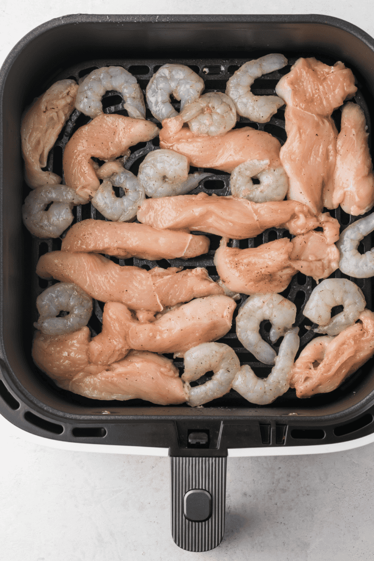 Place chicken and shrimp in air fryer basket in a single layer. Cook for 8-10 minutes, flipping halfway through until cooked through.