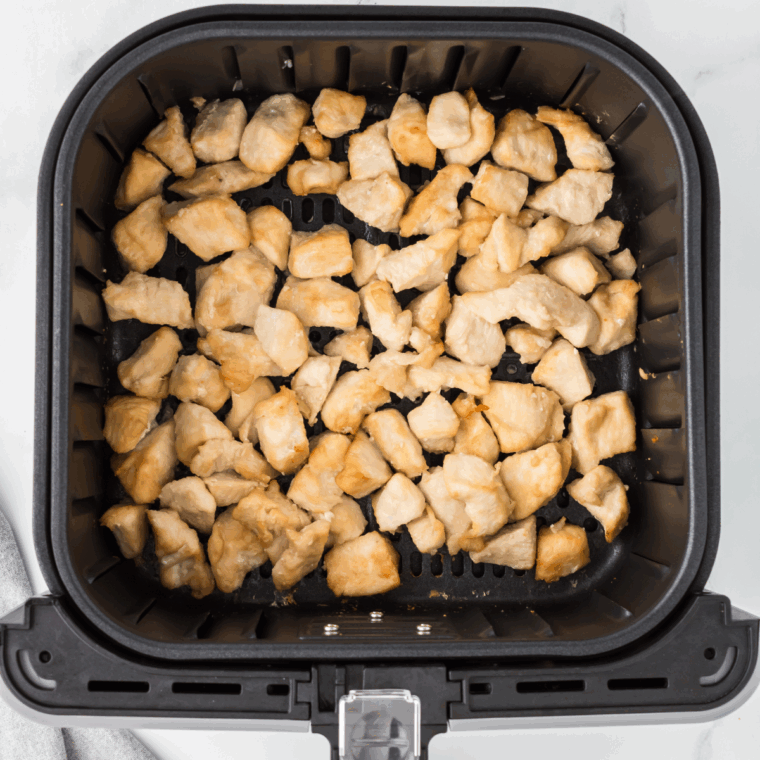 Cooked chicken in the air fryer basket. 