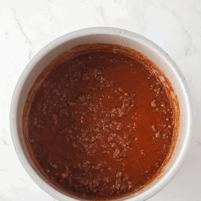 Simmering the sauce in a large saucepan.
