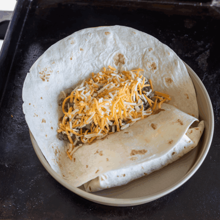Assemble the Burritos: Beef mixture added to tortillas, ready for assembling wet burritos.